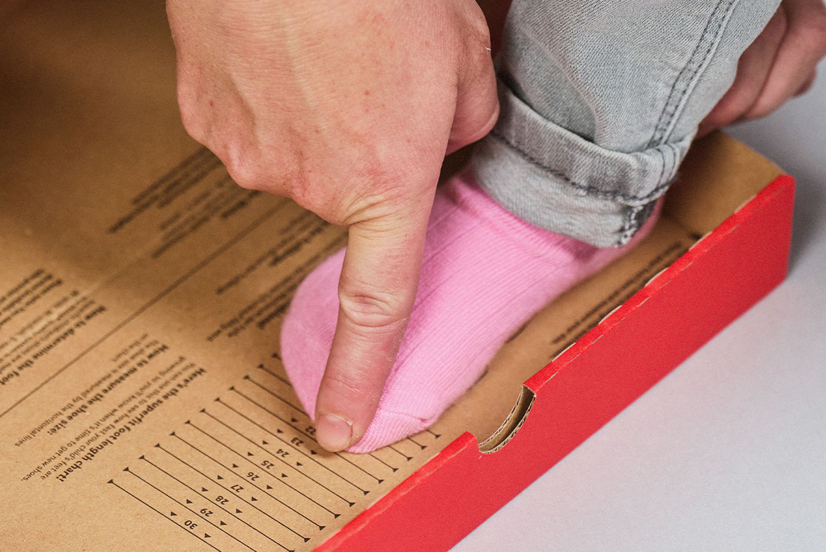 Measuring foot with the superfit measuring template from the shoebox to determine the correct shoe size