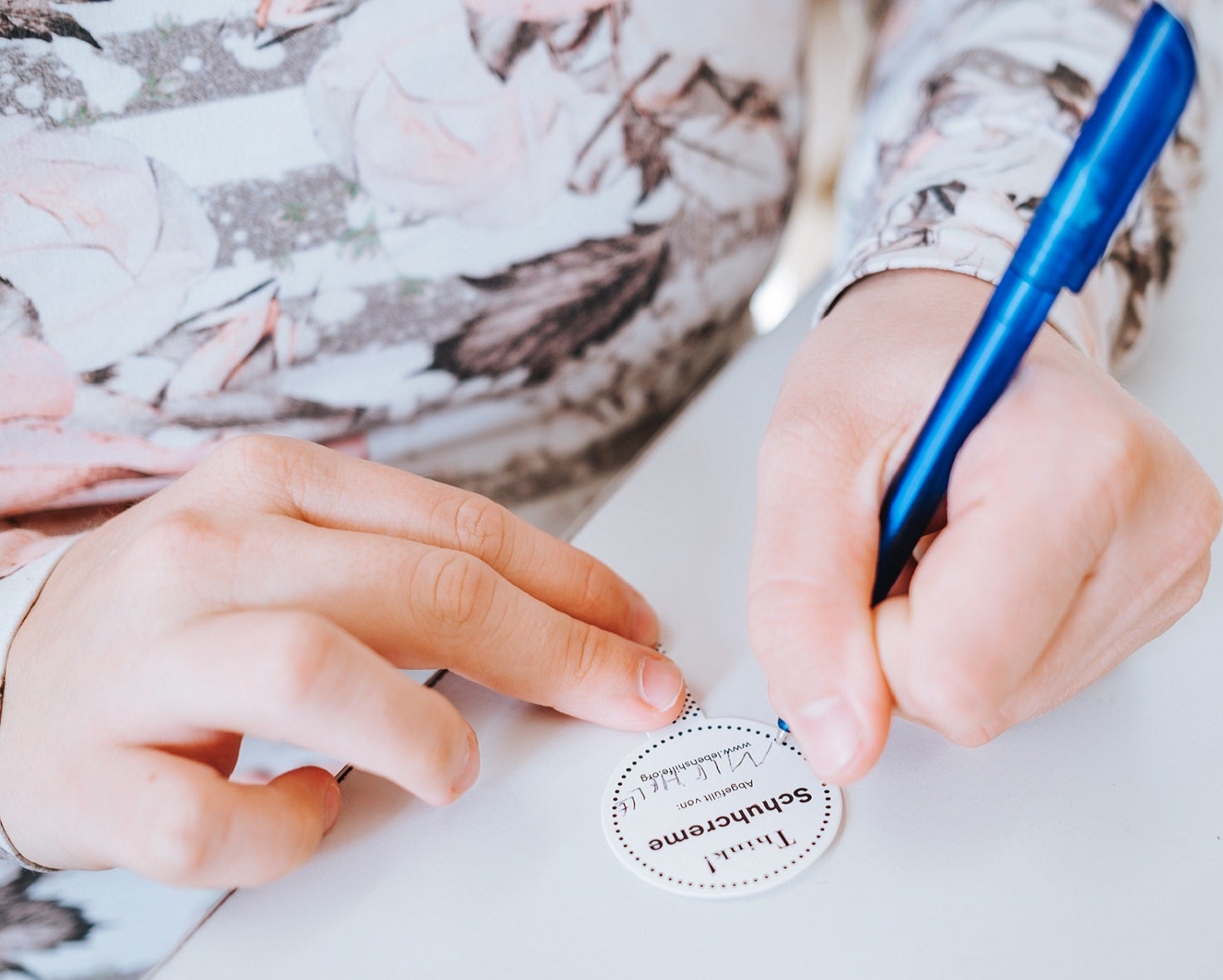 Personalised products from Lebenshilfe - handmade with a personal touch Employee of Lebenshilfe Oberösterreich signs a handmade Think! product